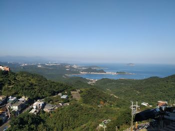 High angle view of townscape by sea against clear sky