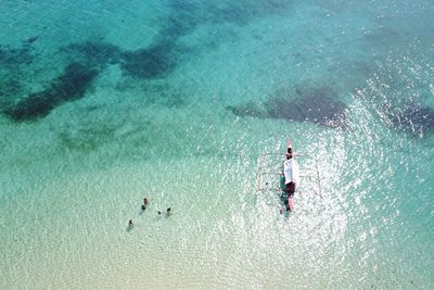 High angle view of people standing in sea