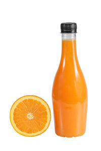 Orange juice in glass bottle against white background