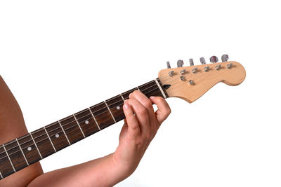 Midsection of man playing guitar against white background