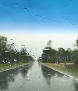 Wet road against sky during rainy season