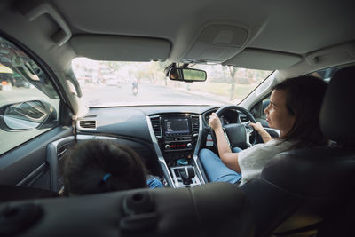 Rear view of woman sitting in car