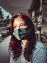Portrait of young woman covering face