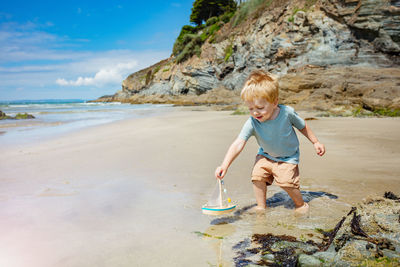 Rear view of boy standing at beach