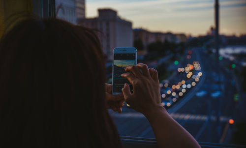 Rear view of woman taking selfie