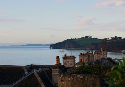 Houses by sea against sky