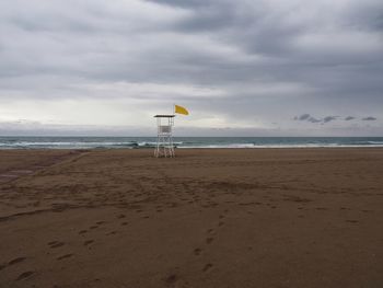 Lifeguard hut on beach against sky