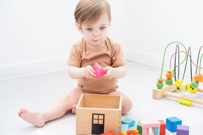 Baby girl playing with toy at home