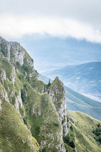 Scenic view of mountains against sky with clouds