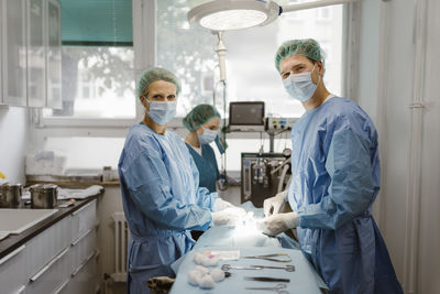 Portrait of male and female veterinarians in operating room at animal hospital