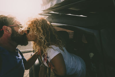 Close-up of couple embracing by car outdoors