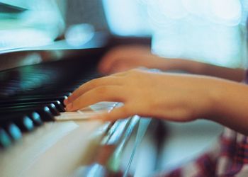 Cropped image of person playing piano