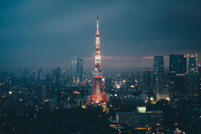 Illuminated buildings in city against sky at night