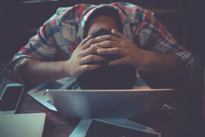 High angle view of stressed man by desktop pc