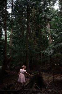 Rear view of woman standing in forest