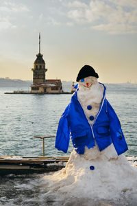 Snowman against maiden tower during winter