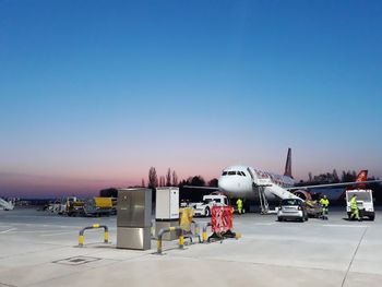 Airplane on airport runway against clear blue sky