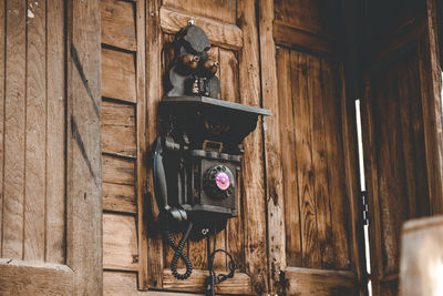 Old telephone hanging on a wooden wall