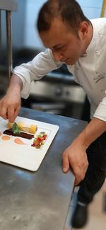 Midsection of man preparing food in restaurant