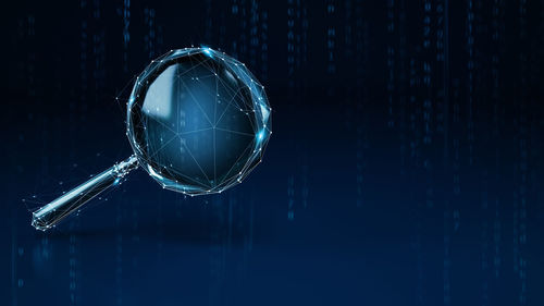 Close-up of crystal ball on glass against blue background