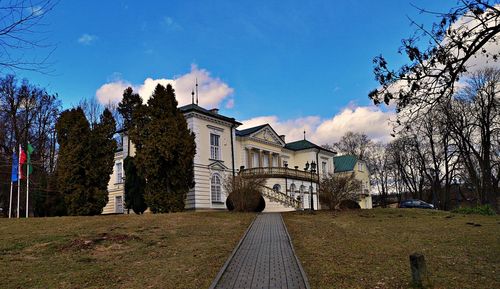 Footpath amidst buildings against sky