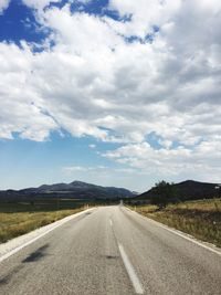 Empty road against cloudy sky