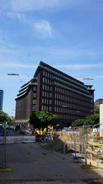 Street by buildings against sky in city