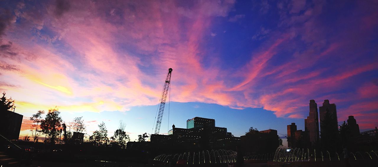 sunset, silhouette, building exterior, architecture, built structure, sky, city, orange color, cloud - sky, low angle view, cloud, tall - high, dusk, crane - construction machinery, tower, development, building, dramatic sky, construction site, outdoors