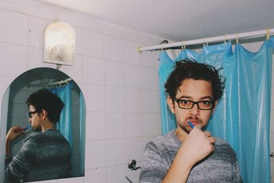 Portrait of young man with reflection on wall