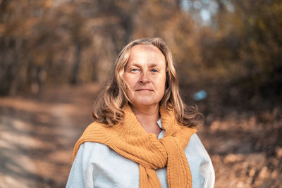 Portrait of woman standing by tree during winter