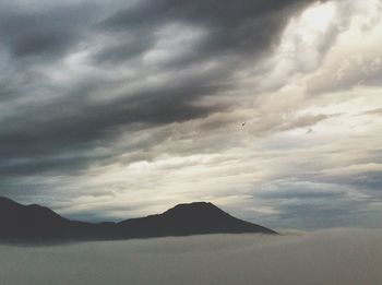 Scenic view of mountains against cloudy sky