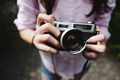 Midsection of woman holding camera