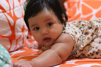 Portrait of cute baby relaxing on bed at home