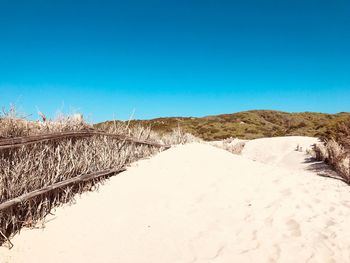 Scenic view of desert against clear blue sky