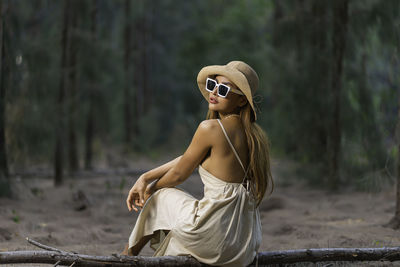 Side view of woman sitting outdoors