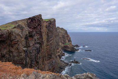 Rock formations by sea against sky
