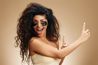 Portrait of young woman with eyes closed against white background