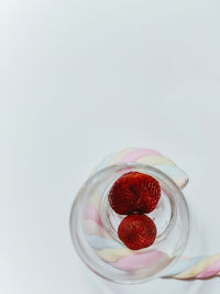 Close-up of strawberry on glass against white background
