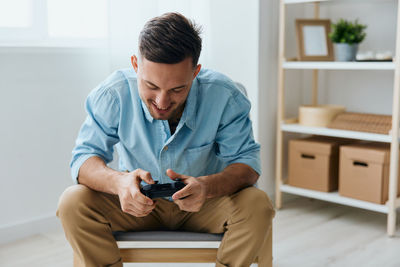 Boy using phone while sitting on table