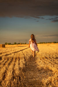 Rear view of woman standing on field