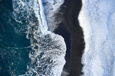 Breaking waves rolling on seashore in winter