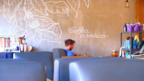 Rear view of man sitting on table at cafe