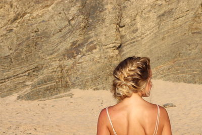 Rear view of woman standing on rock