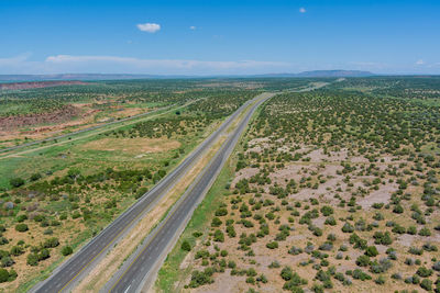 High angle view of road amidst field against sky