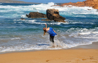 Woman playing with water at seashore