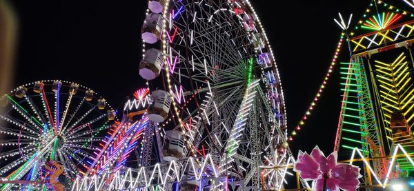 Low angle view of illuminated ferris wheel at night