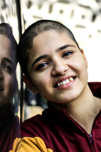 Close-up portrait of smiling woman with shaved head