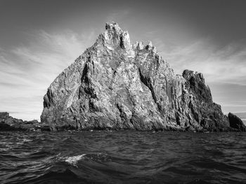 Black and white photo of sea with raw rocks in antarctica