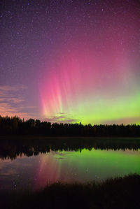 Scenic view of lake against sky at night