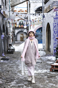 A stylish woman in pastel-colored warm clothes outdoors in the city in winter.snowfall,cold weather.